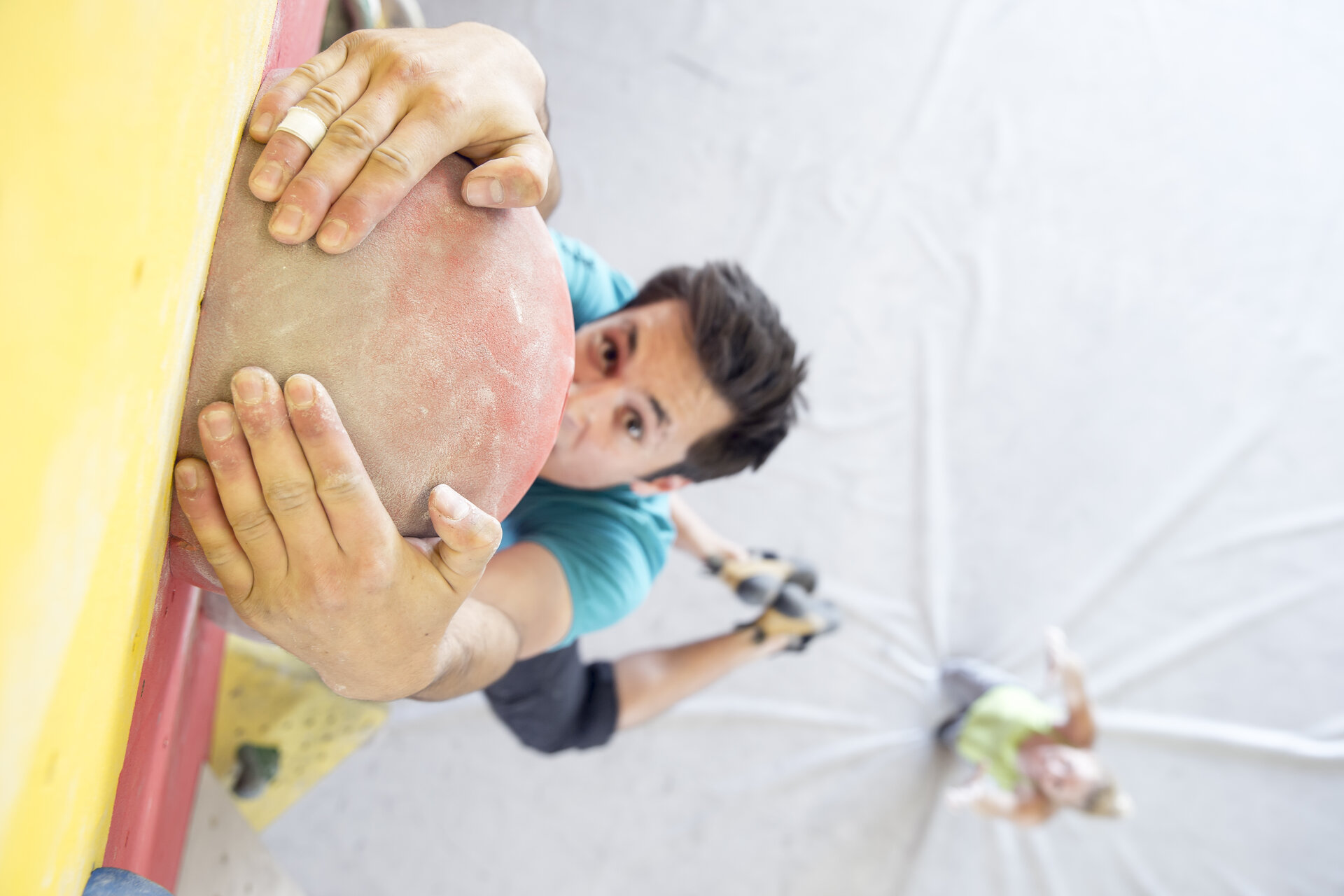 Bouldern | © DAV/ Hansi Heckmair Ein Mann beim Bouldern aus der Vogelperspektive fotografiert, seine Partnerin spottet im Hintergrund. | © DAV/ Hansi Heckmair