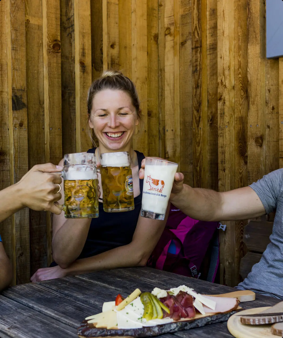 Auf der Hütte: Drei Personen stoßen mit Bierkrügen an | © DAV/Hans Herbig