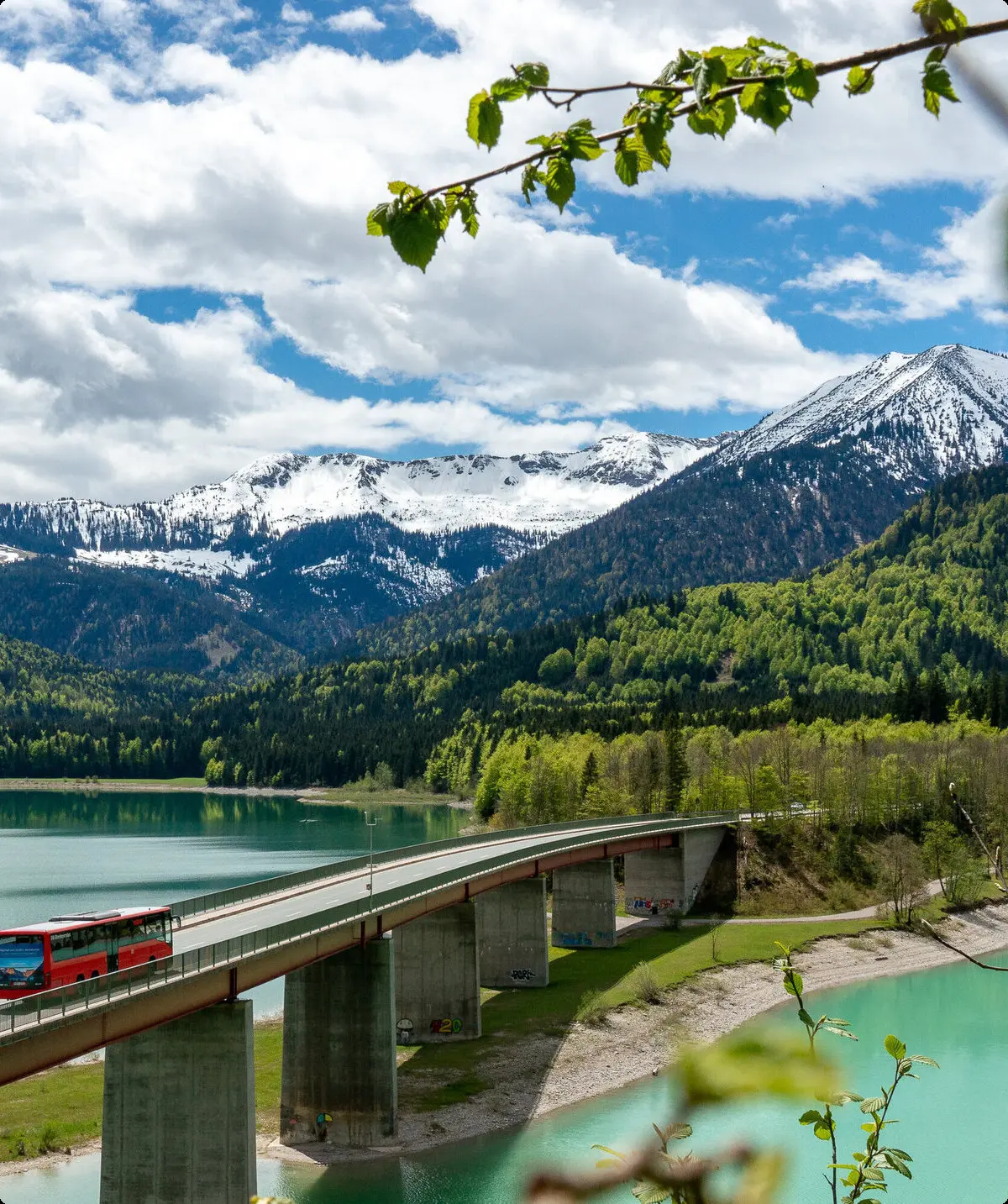 Der Bergbus des Deutschen Alpemvereins fährt über eine Brücke in die Alpen | © DAV/Tobias Hipp